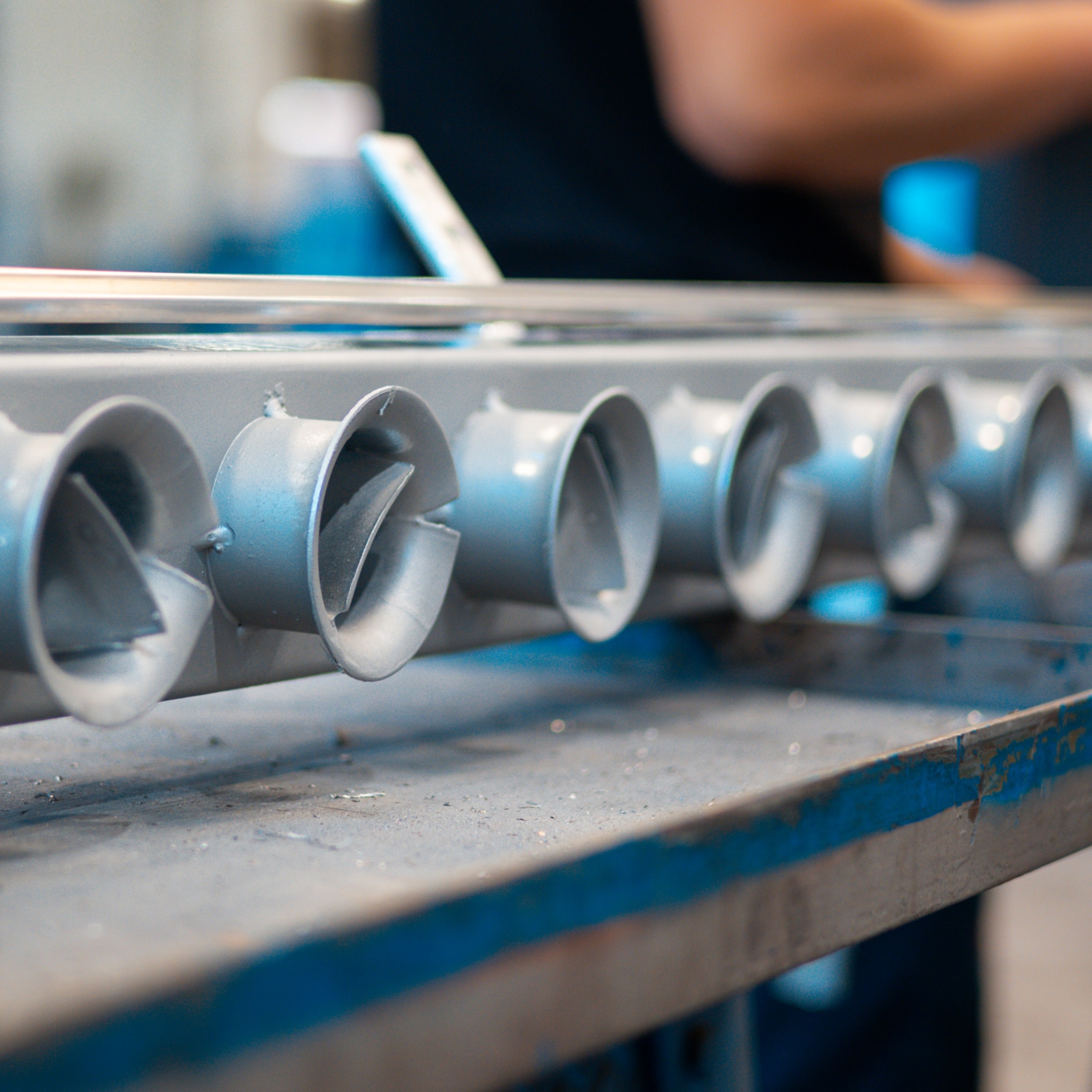 Row of precision-cut spray nozzles on a HelixSpray manifold