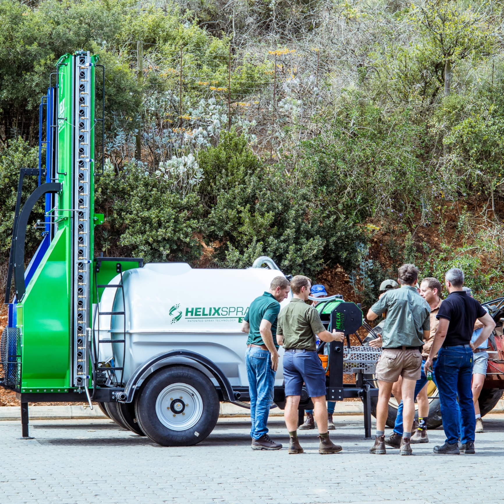 HelixSpray trailer unit displayed outdoors with a group gathered around it