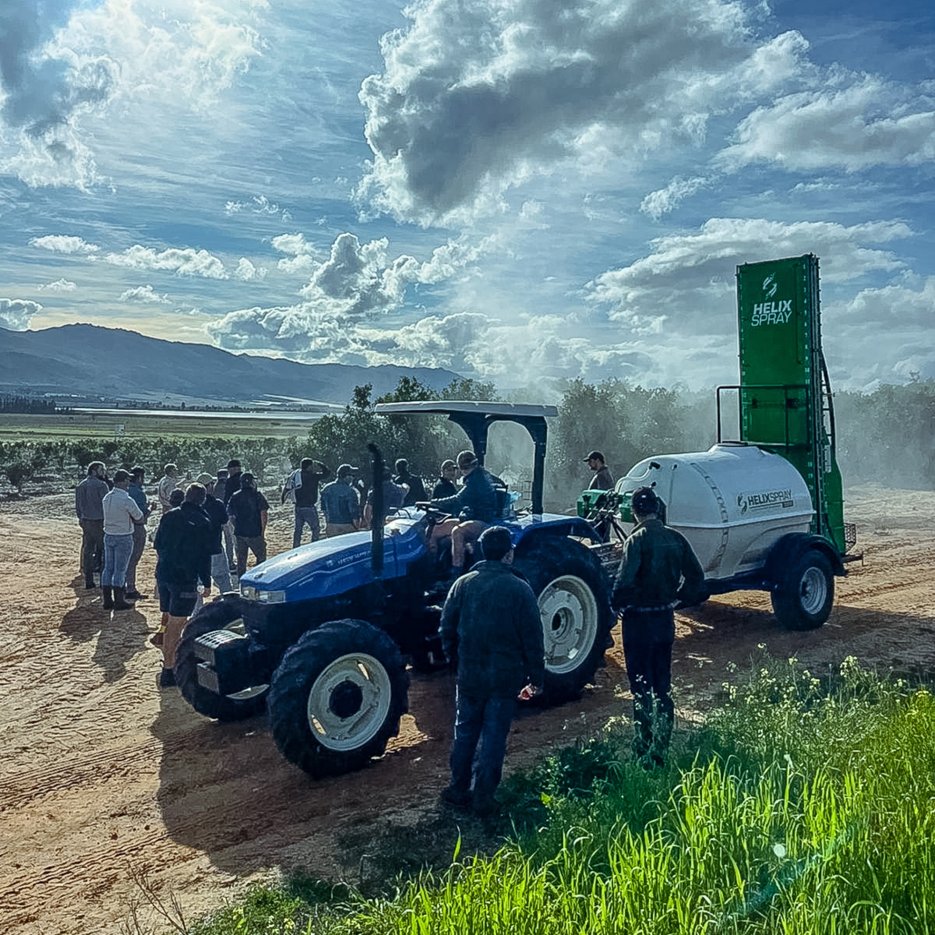 HelixSpray tower sprayer demo in vineyard with tractor and group of farmers