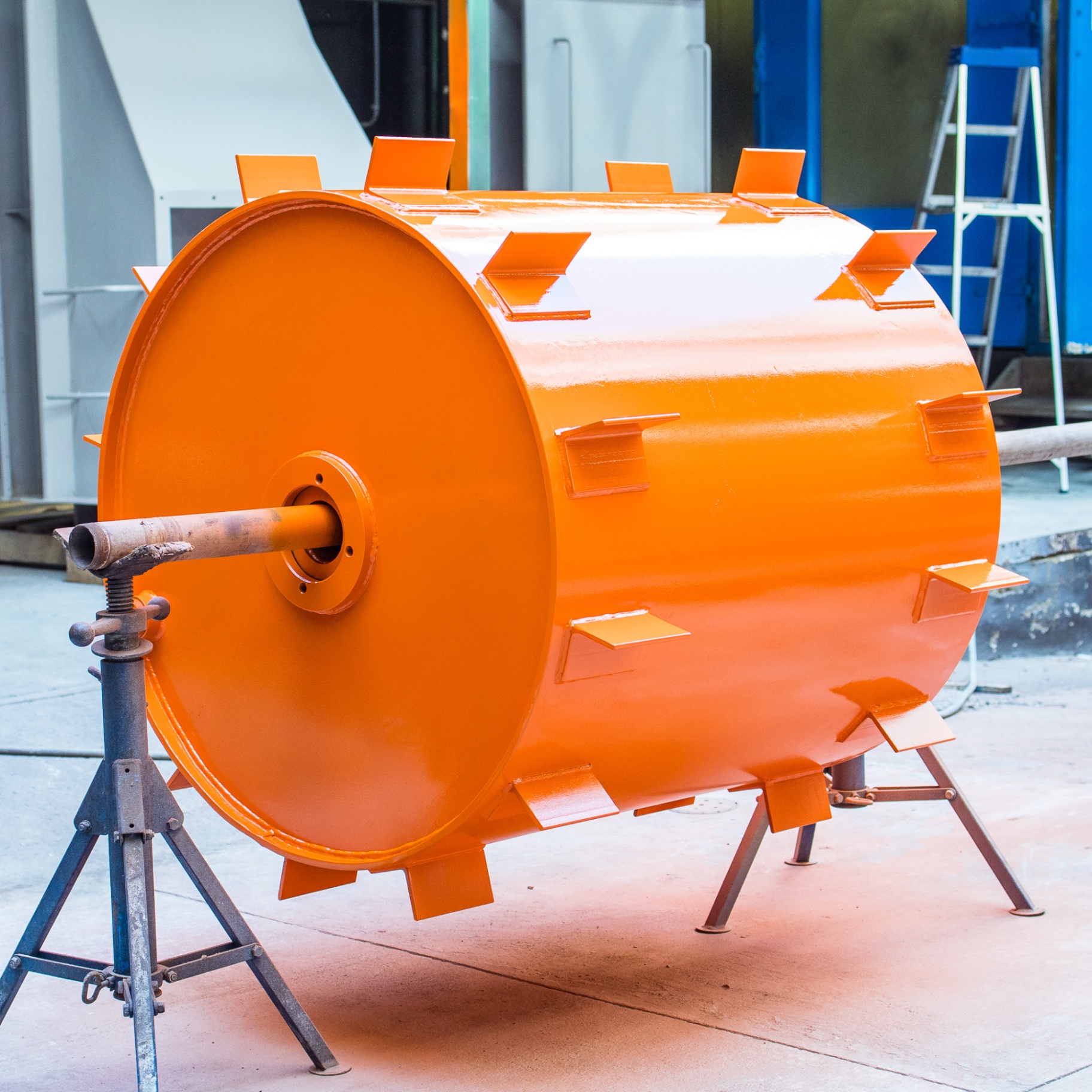 Large orange fan drum mounted on a stand after fresh paint and reassembly