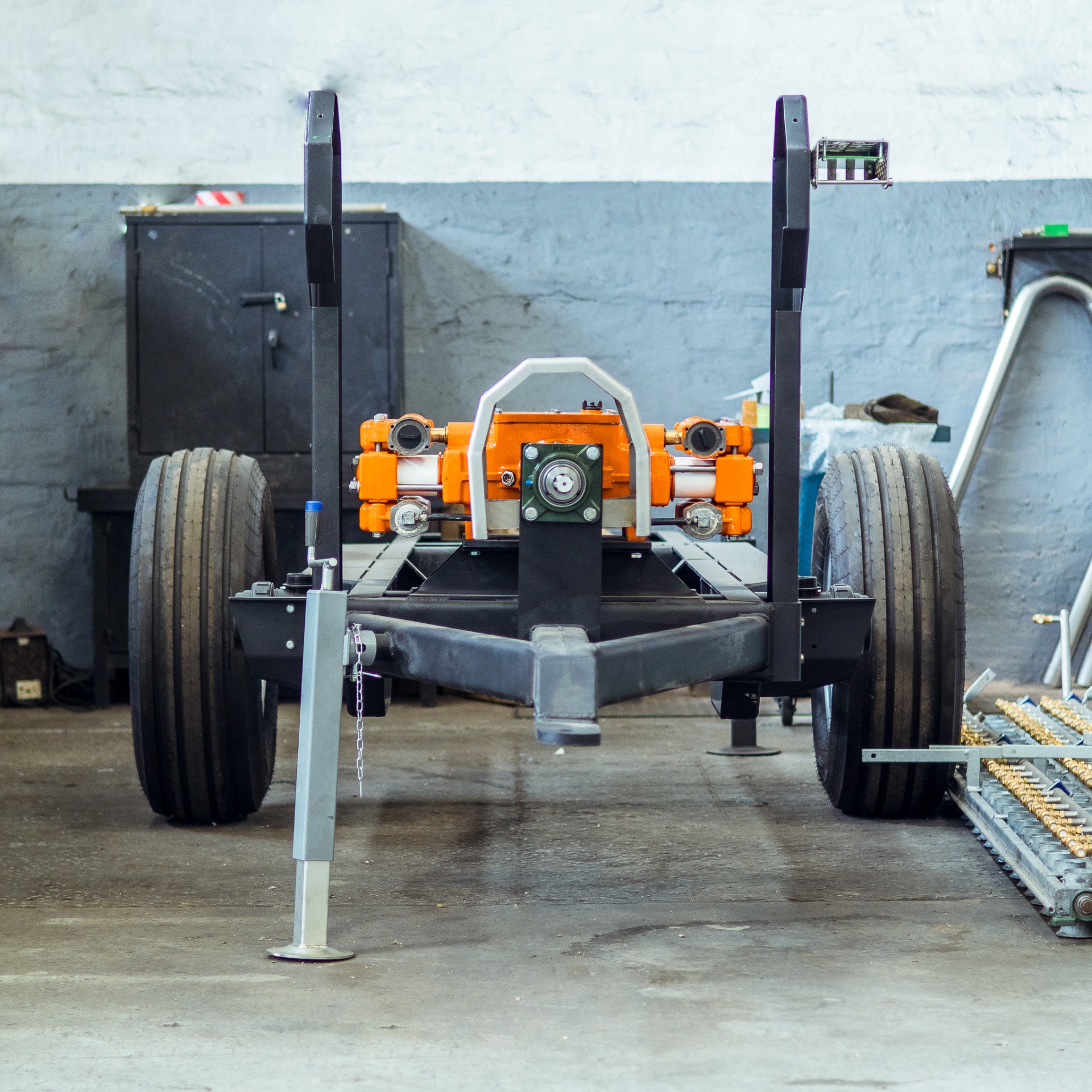 Front view of a freshly built trailer chassis with orange drive unit and twin wheels