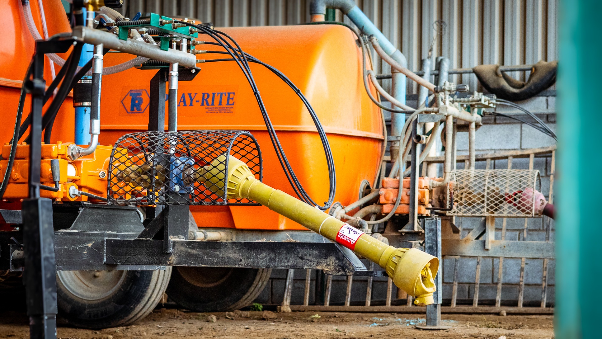 Workshop fabricating an orchard sprayer with citrus orchard visible outside